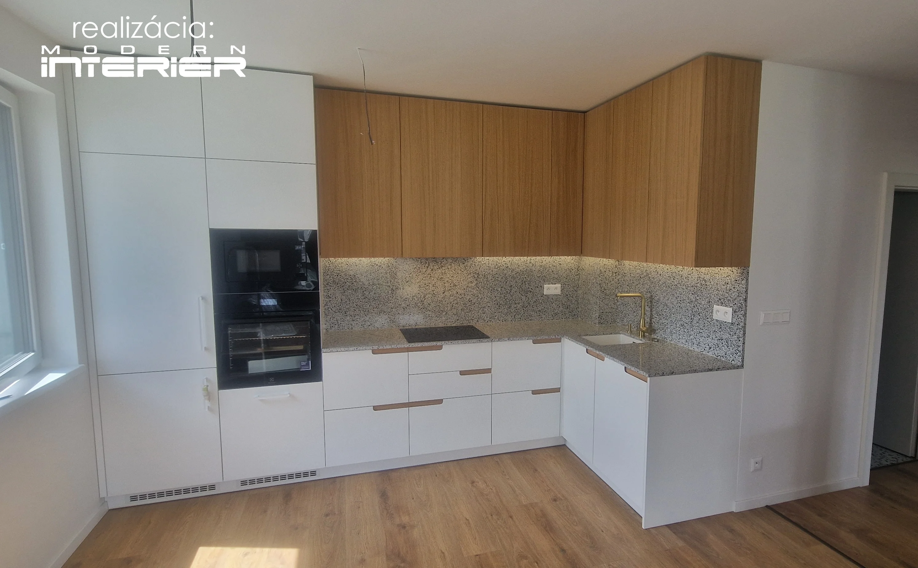 Bielo-drevená rohová kuchyňa na mieru s kamennou zástenou, vstavanými spotrebičmi a elegantnou batériou